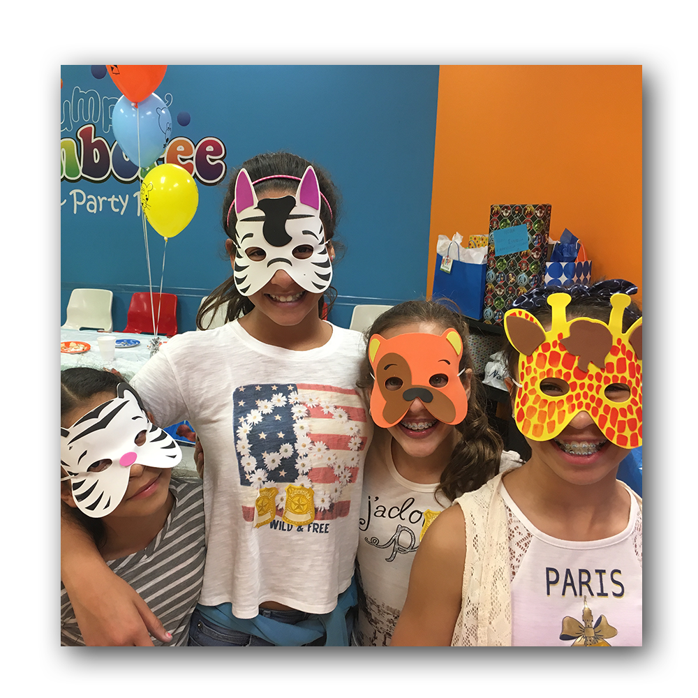 four young girls wearing animal masks