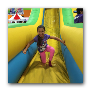 young girl getting off of jumpy castle
