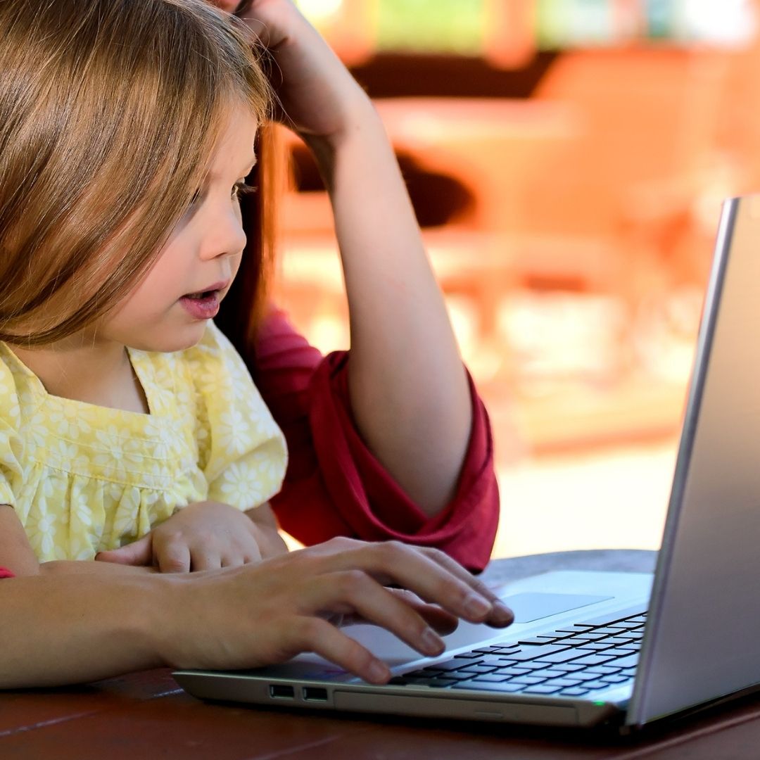 parent working with child on computer